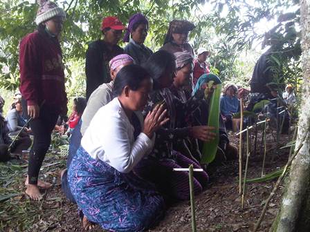 Kaum ibu warga Desa Gurusinga tampak memanjatkan doa sembari meletakkan sirih dan rokok sebagai persembahan.