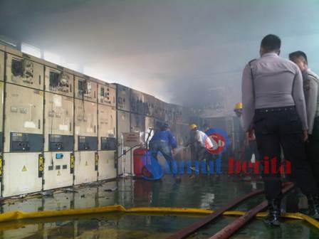 Petugas Pemadam Kebakaran dibantu petugas PLN saat memadamkan kobaran api di dalam gardu. SUMBER/pardi simalango
