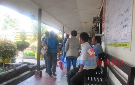 Bendahara BPBD Karo, Berta br Surbakti (baju kaos biru) buru-buru meninggalkan ruang Unit Tipikor Polres Karo, usai menjalani pemeriksaan. SUMBER/pardi simalango