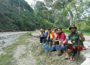 Dandim 0205/TK Letkol (Inf) Agustatius Sitepu didampingi tim relawan beristirahat sejenak usai mencari korban hilang banjir lahar dingin di persimpangan Sungai Lau Borus. SUMBER/dok