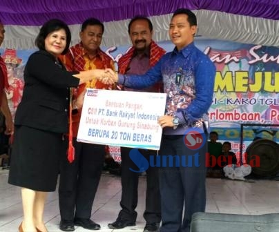 Pinca BRI Kantor Cabang Kabanjahe Sudono saat memberikan bantuan beras 20 ton secara simbolis yang diterima oleh Wabup Karo Cory Sriwati Sebayang di Berastagi, Selasa (31/05/2016). SUMBER/dok