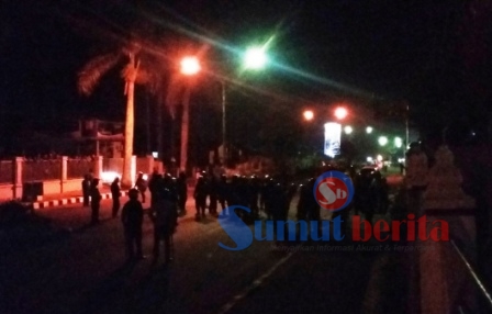 Puluhan personel polisi berjaga-jaga di depan Mapolres Karo, mengantisipasi serangan susulan dari warga Desa Lingga, Jumat (29/07/2016) malam. SUMBER/pardi simalango