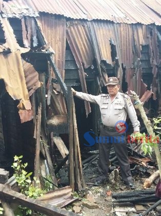Salah seorang personel Polsek Payung menunjukkan salah satu asrama Polres Karo di Batu Karang yang terbakar. SUMBER/pardi simalango