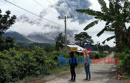 Terlihat dari simpang Desa Guru Kinayan, Gunung Sinabung mengeluarkan awan panas guguran dengan jarak luncur sejauh 4.000 meter ke arah Tenggara-Timur, Jumat (26/8). SUMBER/susanto ginting (fb)