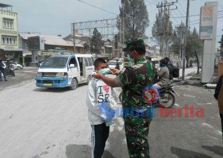 Dandim 0205/TK Letkol (Inf) Agustatius Sitepu, mengenakan masker kepada seorang pelajar SMP di Kota Berastagi. SUMBER/pardi simalango