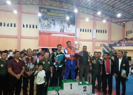 Pelatih Utama KTC, Karta Aprianus Simalango S.Pd (berdiri di podium tengah) saat menerima trofi Juara I Umum pada kejuaraan Taekwondo Terbuka Piala Pangdam I/BB di GOR Futsal Dispora Sumut. SUMBER/pardi simalango